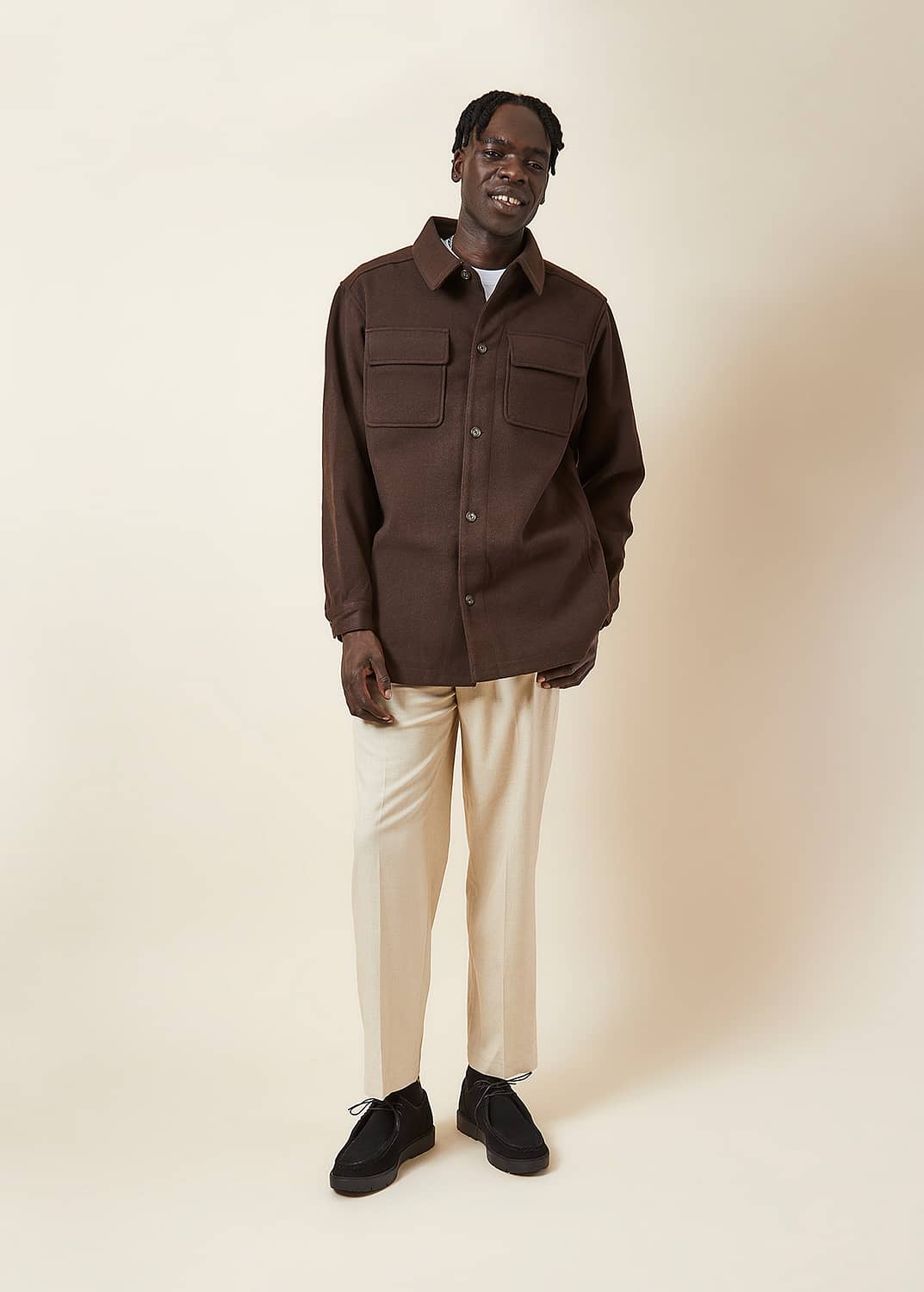 Model photography wearing brown coat and cream chinos